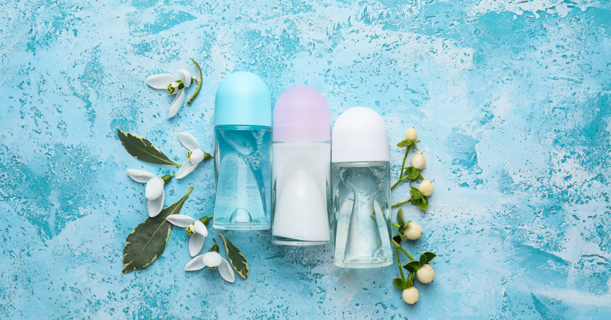 A selection of antiperspirant sprays and roll-on containers arranged on a blue background, illustrating aluminium-based antiperspirant products