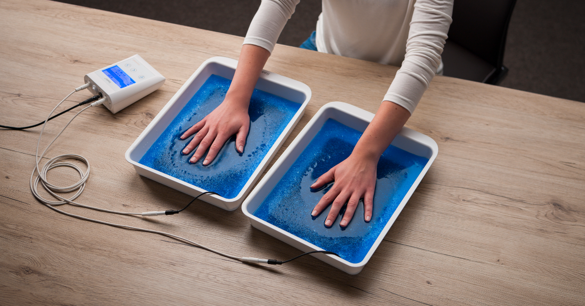 Hands placed in iontophoresis water trays during a hyperhidrosis treatment session